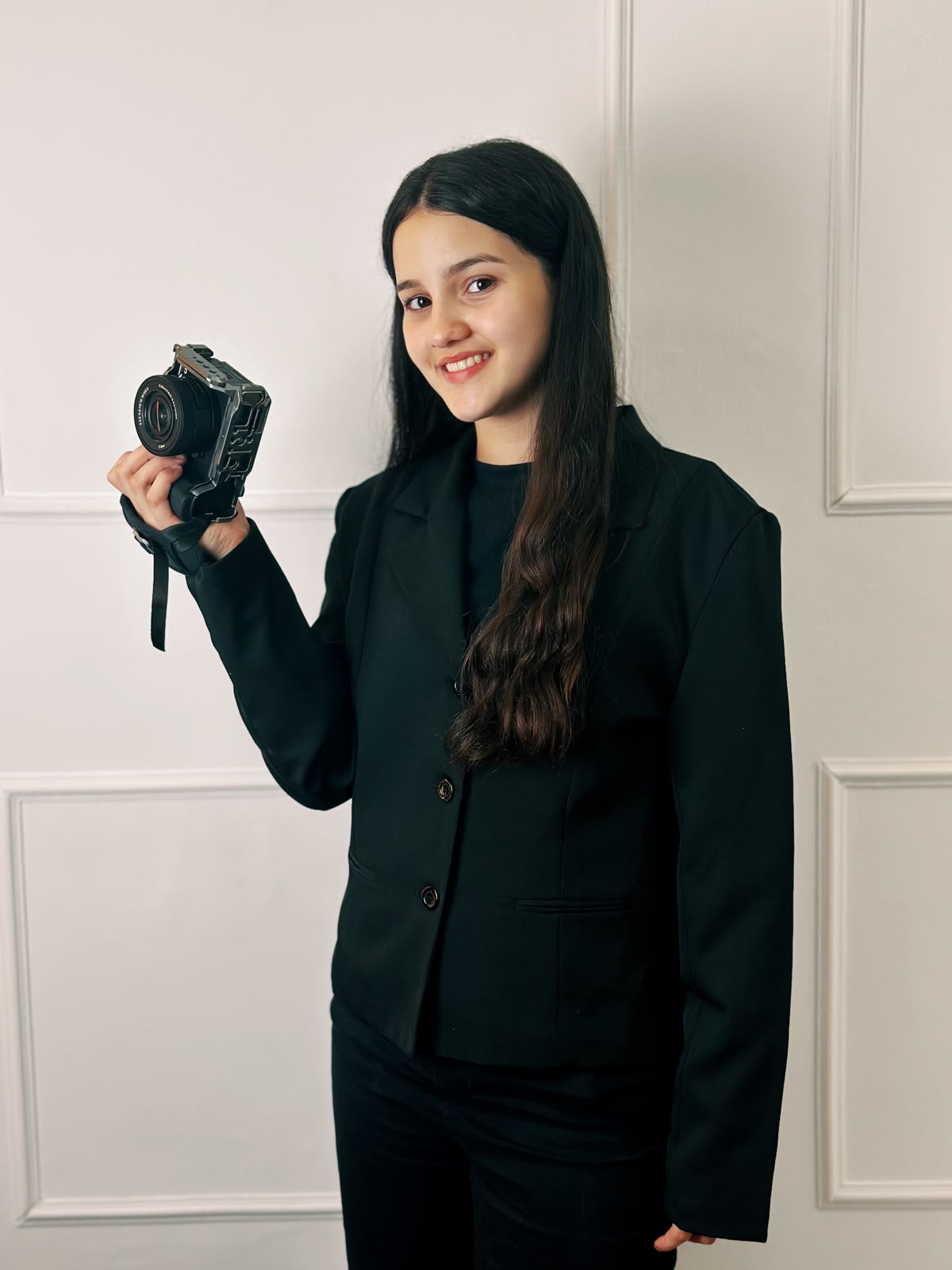 Giovanna sorrindo e segurando sua câmera fotográfica